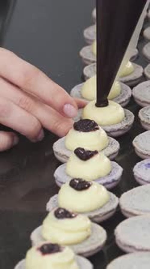 Assembly of Delicious Macarons with Cream and Chocolate