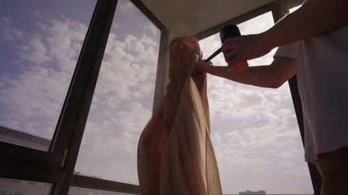 Person Cleaning Curtains in a Modern Apartment