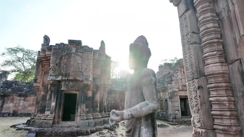 Cinematic low-angle close-up of ancient Khmer temple deity statue silhouette, with bright golden