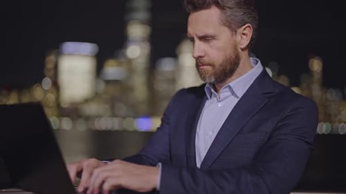 Businessmen Working on Laptop on Evening Lights of the Night City Business in New York City Finance