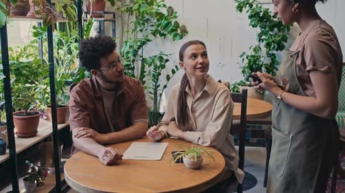 Multiethnic Young Couple Ordering Lunch in Cafe