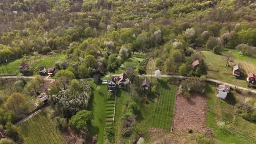 Aerial view of a forested landscape and a small village in spring