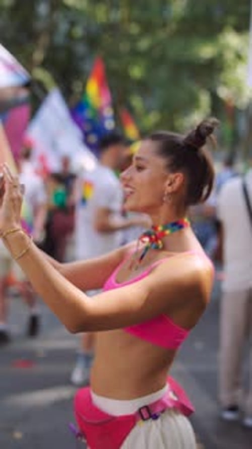 Young Woman Filming Pride Parade with Phone