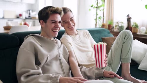 Gay Couple Laughing and Watching Comedy at Home