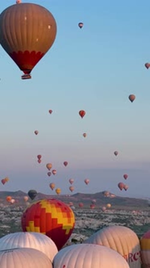 Vertical Video Hot Air Balloons Fly Over the Mountainous Landscape of Cappadocia Turkey