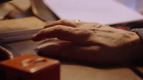 Hand operating computer mouse on desk close up