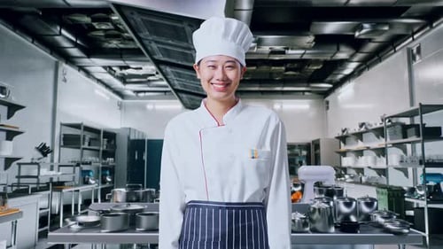 Asian Woman Chef Standing And Smiling To Camera In Kitchen