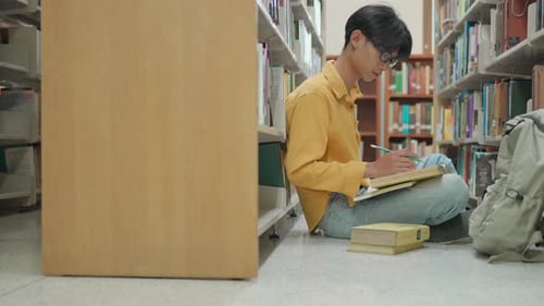 Young Asian University Student reading in a library