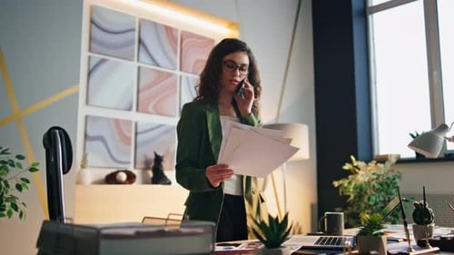 Successful businesswoman speaking on smartphone in modern office building