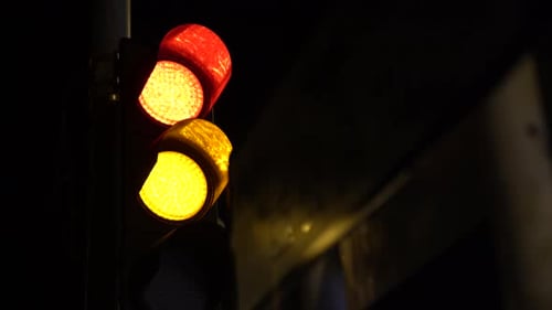 Semáforos de carros ficando verdes de vermelho e ficando vermelhos de verde. Tiro no escuro em uma cidade grande