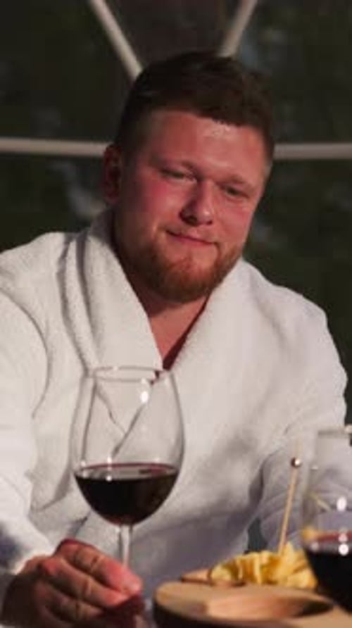 Un homme soulève un verre à vin en clignotant avec une femme