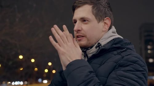 Man Warming Hands in Cold Urban Night