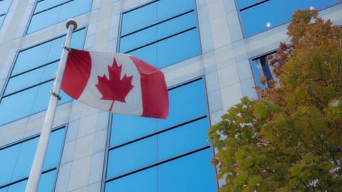 Canadian Flag Waving in Front of Office Building