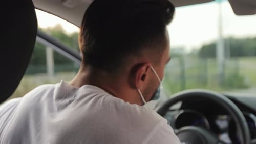 Young Adult Removes Face Mask While Driving