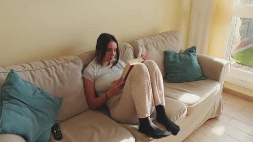 Woman Relaxing at Home and Reading a Book