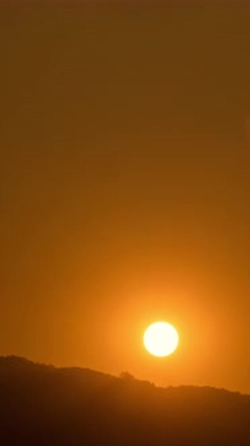 Timelapse of dramatic sunset with orange sky in a sunny day.