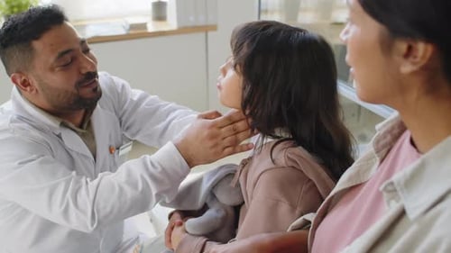 Gentle Doctor Examines Child's Neck in Doctor's Office