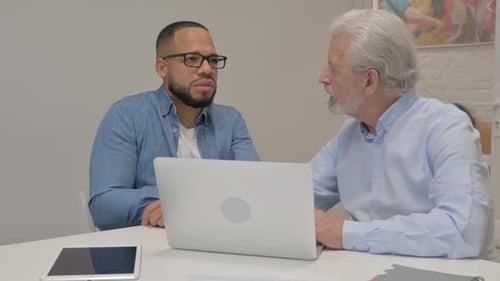 Old Businessman Talking with Young Man in Office