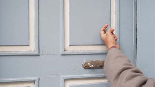 Hand Knocks on Weathered Painted Blue Door