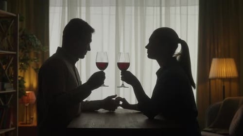 Romantic Couple Silhouette Drinking Wine and Holding Hands