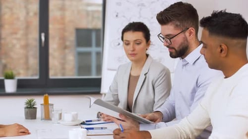 Business Meeting with Diverse Team Reviewing Documents