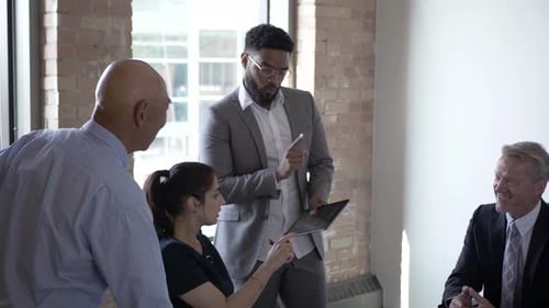 Professionals Discussing Tablet in an Office Meeting