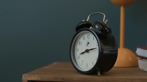 Wecker mit manuellem Ausschalten auf dem hölzernen Nachttisch im Schlafzimmer