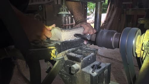 Man Drilling Wood Block with Lathe in Workshop