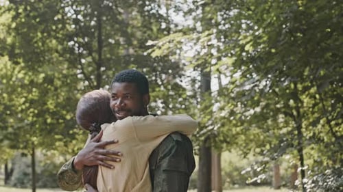 Smiling Soldier Hugging Wife in Park