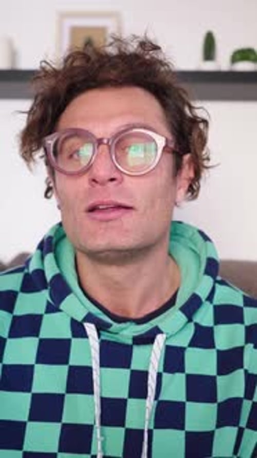 Un comunicador científico adulto caucásico graba un tutorial en vídeo en la sala de estar, en casa, un nerd man