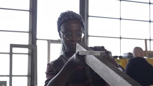 Woman Measures Wooden Plank in Workshop, Craftsman at Work