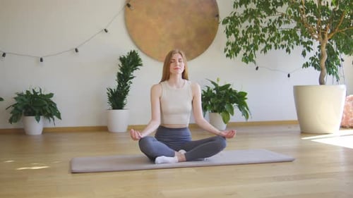 Woman Meditating Peacefully in Sunny Indoor Setting