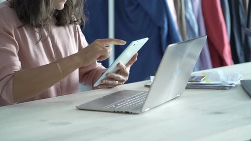 Young businesswoman works with tablet and laptop at her modern office table