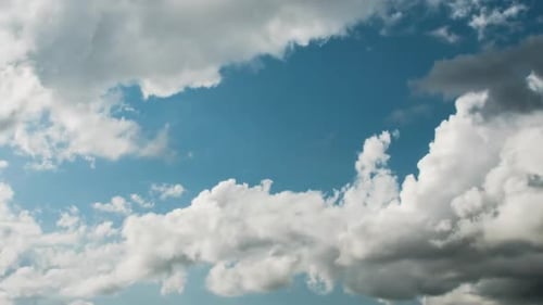 Zeitraffer: Weiße Wolken bewegen sich über einen blauen Himmel
