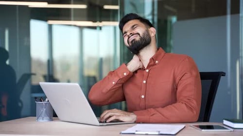 Man Experiencing Neck Pain While Working on Laptop