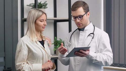 In Medical Office Concerned Doctor Talks with a Beautiful Blonde Woman. Health Care Professional Con