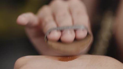 Applying Brown Cosmetic to Skin with Applicator