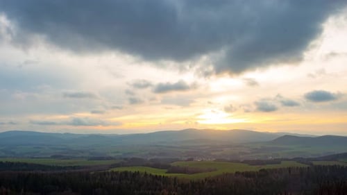 Zeitraffer von Wolken, die sich bei Sonnenuntergang schnell über einem Bergdorf bewegen