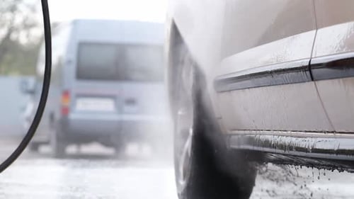 Car Being Washed with High-Pressure Water Sprayer