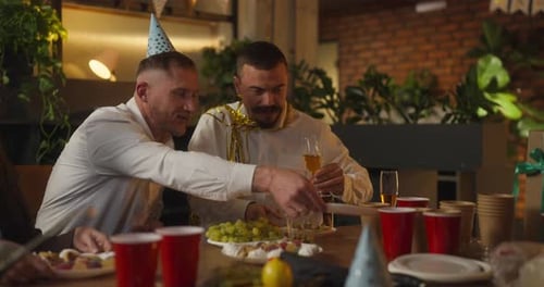 Dois caras em um terno de negócios colocam pratos na mesa e se comunicam durante um evento corporativo e