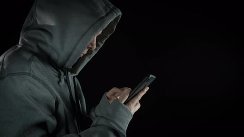 Person with Hoodie Using a Mobile Phone
