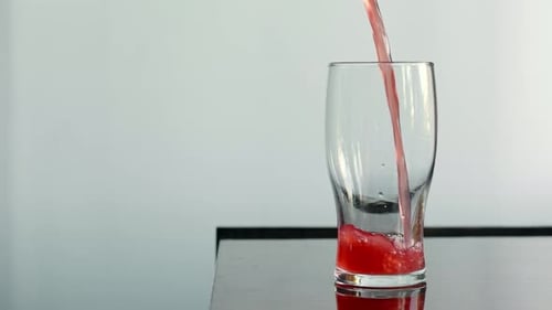 Pouring Red Liquid into Clear Glass Indoors