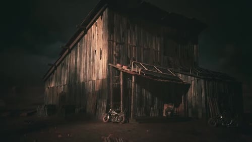 Granero rústico de madera iluminado por una iluminación Dramática por la noche en un entorno rural