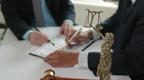 Two People Signing a Contract at a Table
