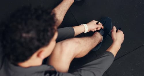 Above, man and tie shoes in gym for fitness, run or start exercise routine with laces for health