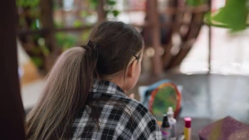 Back View of Lady Applying Makeup with Mirror Reflection