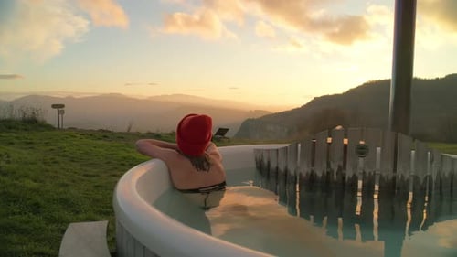 Young Woman Glamping in Outdoor Wooden Hot Tub