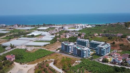 Blick auf das Meer und die Gegend von Hotels und Häusern mit grünen Feldern