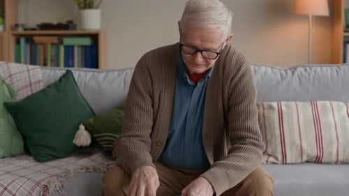 Concerned Man Reviewing Overdue Bills and Calculating Expenses at Home