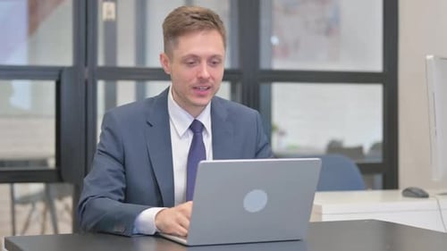 Man Using Laptop at Desk in Office